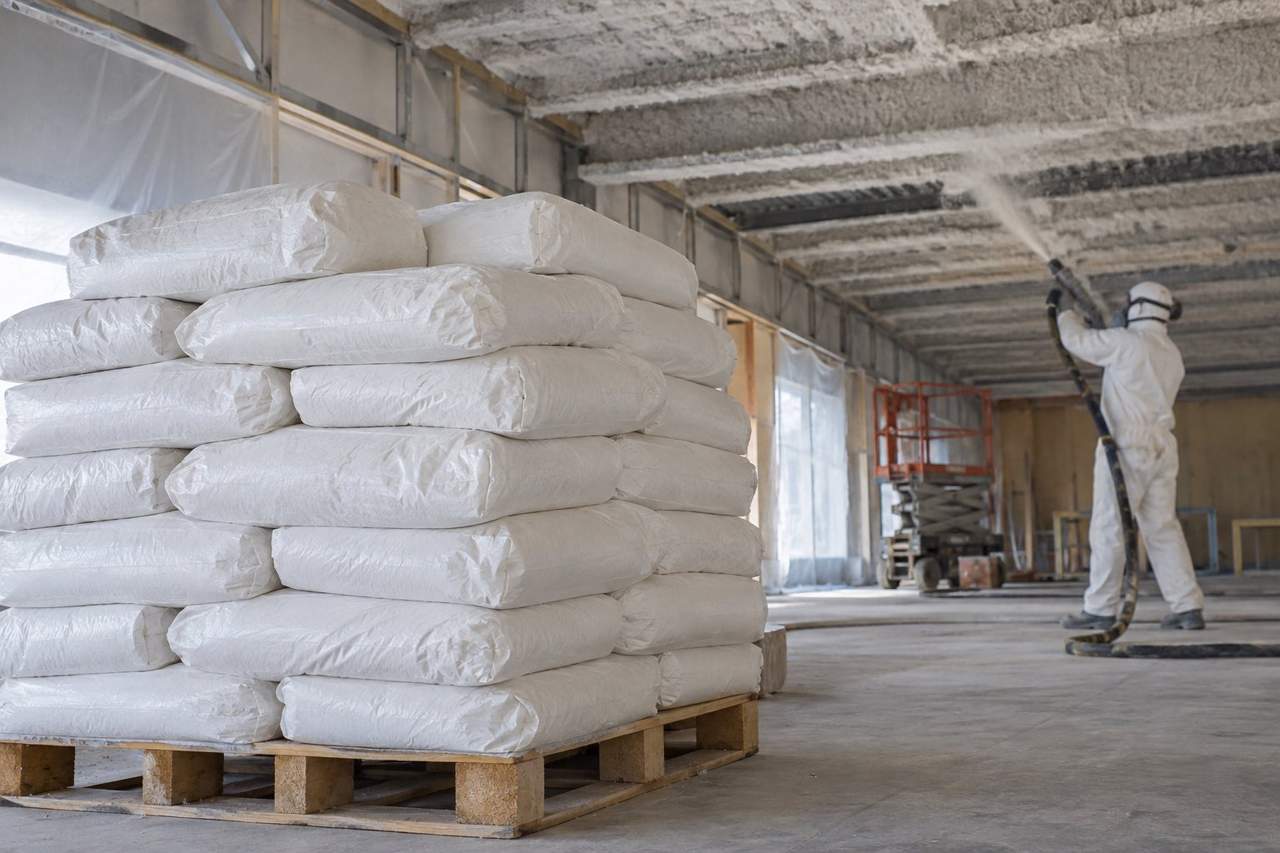 Illustration of bagged fibre material staged beside overhead spray work